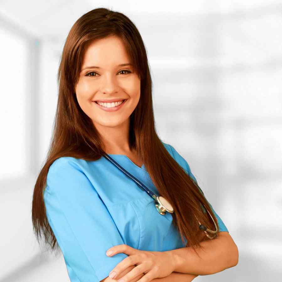 Smiling female nurse in blue scrubs with arms crossed.