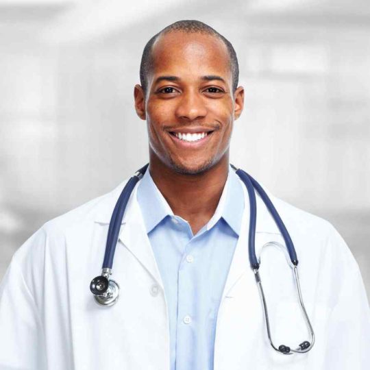 Smiling male doctor with stethoscope in a professional setting.