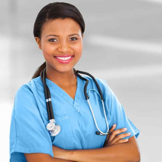 Smiling healthcare professional in blue scrubs with stethoscope.