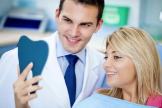 Doctor showing a patient something on a tablet, both smiling.