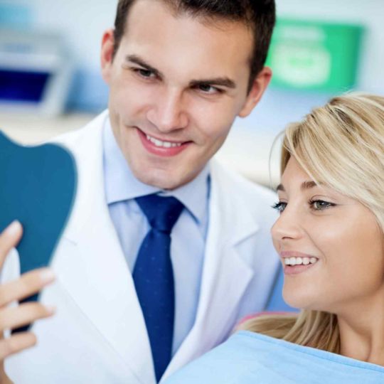 Doctor showing a patient something on a tablet, both smiling.