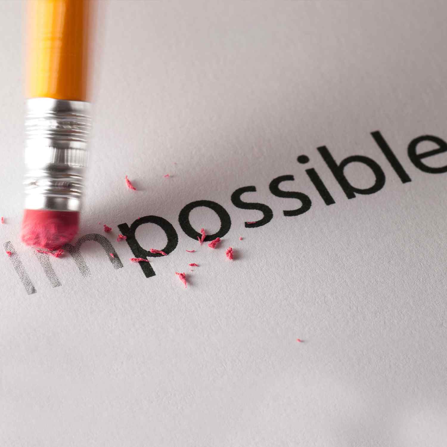 Eraser removing the 'im' from 'impossible', symbolizing turning impossible into possible.