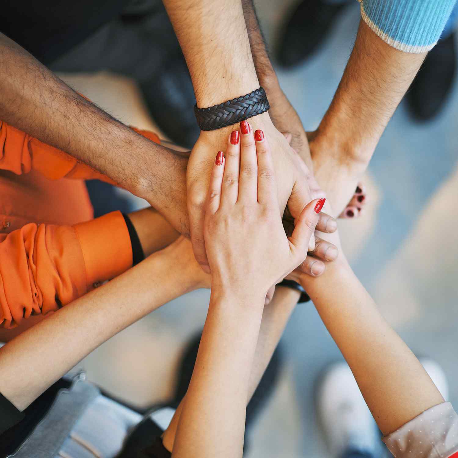 Multiple hands stacked together, symbolizing unity and teamwork.