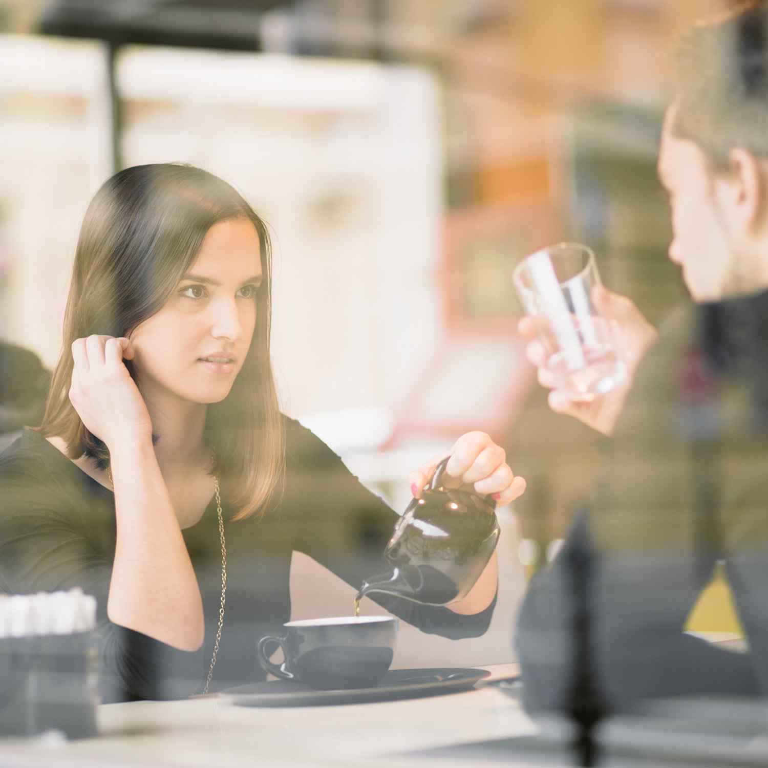 Two women having a conversation over coffee in a cozy café.