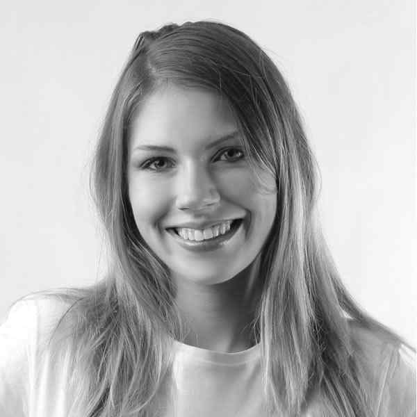 Smiling woman with long hair in a black and white portrait.