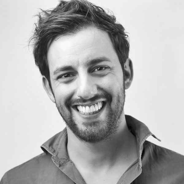 Smiling young man with casual hair and beard.