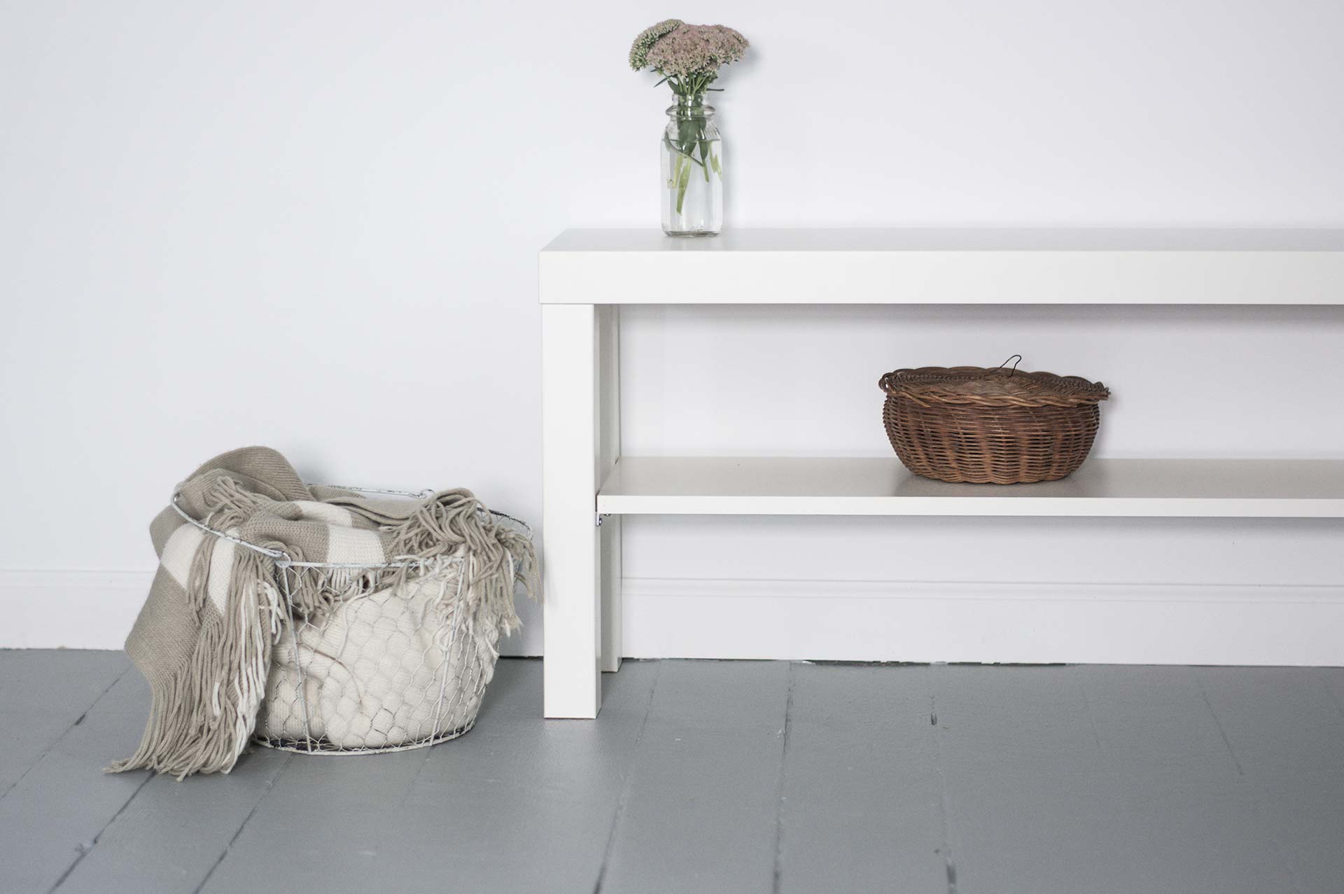 White shelf with basket and flowers vase.