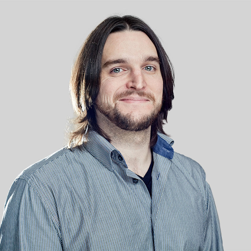 Man with long hair wearing a striped shirt.