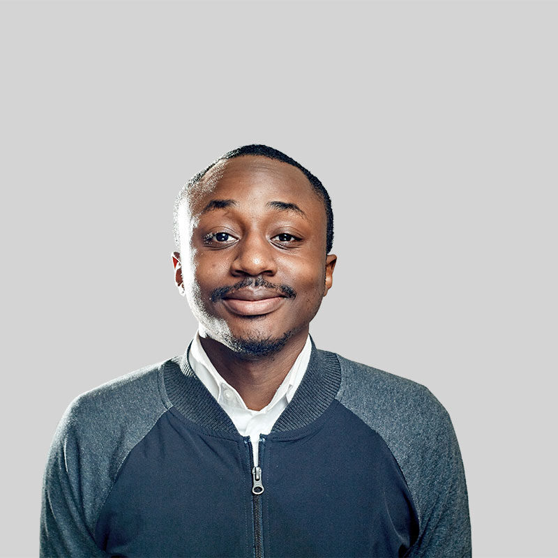 Smiling man in gray sweater portrait.